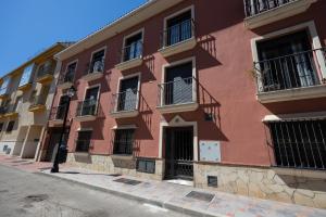 un edificio rosso con balconi su strada di Atico Gran Esperanza a Fuengirola