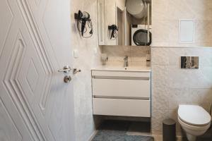 un baño con inodoro y lavabo en Apartment Aria 3, en Velingrad 20 fotos más