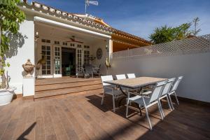 フエンヒロラにあるVilla Casa Colón - Piscina privada - Barbacoa - Fuengirola - VitviHolidaysのデッキにテーブルと椅子が置かれたパティオ