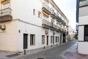 a white building with balconies on a street at Oviedo Puerto in Fuengirola