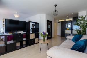 Televízia a/alebo spoločenská miestnosť v ubytovaní Apartamento Perla