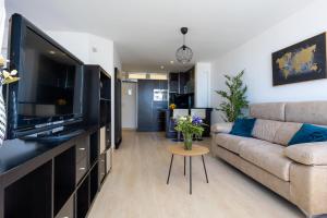 Televízia a/alebo spoločenská miestnosť v ubytovaní Apartamento Perla