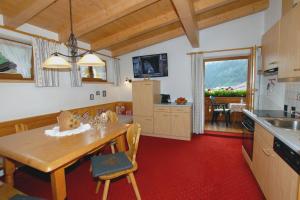 a kitchen with a wooden table and a dining room at Haus Tasser in Mayrhofen