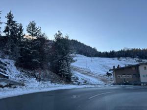 a road with snow on the side of a mountain at Andys Secret Apartment in Leutasch