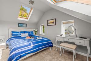 a bedroom with a bed and a desk and a mirror at Seascape in Torpoint