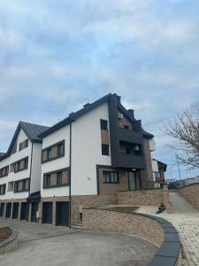 a large white building with a brick wall at Apartman Pinea in Samobor
