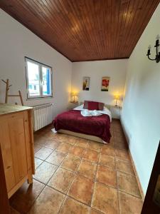 a bedroom with a bed and a wooden ceiling at Quinta do Cutato - Soba Guest House in Santo Estêvão