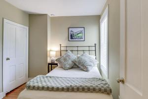 a bedroom with a bed with pillows and a window at Walk to Old Town Chic Alexandria Abode with Patio! in Alexandria