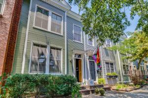 a green house with a flag in front of it at Walk to Old Town Chic Alexandria Abode with Patio! in Alexandria