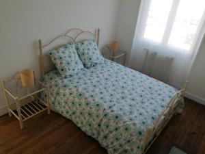 a bedroom with a bed with blue sheets and a window at L'Héritage in Abbeville