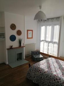 a bedroom with a bed and a fireplace at L'Héritage in Abbeville