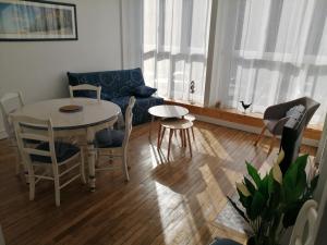 a living room with a table and chairs and a couch at L'Héritage in Abbeville