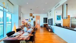 a dining room with a long table and chairs at Oceanview 2BR Bliss in Al Raha - Pool & Balcony Near Al Raha Beach in Abu Dhabi