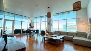 a living room with a couch and a table at Oceanview 2BR Bliss in Al Raha - Pool & Balcony Near Al Raha Beach in Abu Dhabi +49 photos