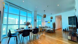 a living room with a table and chairs and a couch at Oceanview 2BR Bliss in Al Raha - Pool & Balcony Near Al Raha Beach in Abu Dhabi