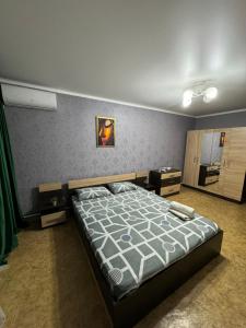 a bedroom with a large bed in a room at Apartments Tsiolkovsky in Pavlodar