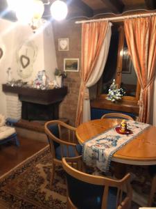 a dining room with a table and a fireplace at Casa Gugjet Cuore Carnico - appartamento Zoncolan - giardino - no scale - parcheggio e 4 zampe gratis in Arta Terme