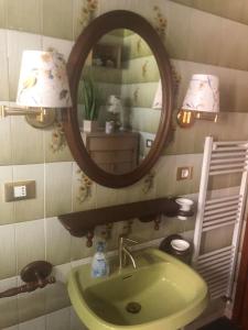 a bathroom with a green sink and a mirror at Casa Gugjet Cuore Carnico - appartamento Zoncolan - giardino - no scale - parcheggio e 4 zampe gratis in Arta Terme