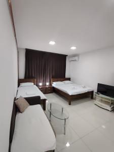 a room with two beds and a flat screen tv at Apartments S&S in Konjic