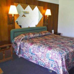 Una habitación de hotel con una cama y dos lámparas. en Kings Inn Cleveland, en Strongsville