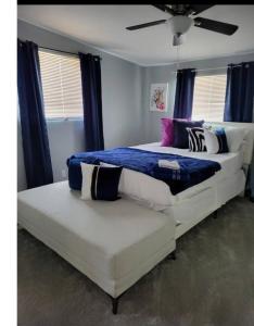 a bedroom with two beds with blue and white pillows at Pool home in Las Vegas