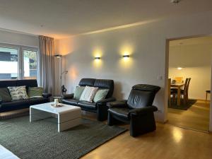 a living room with a couch and two chairs and a table at Gipfelblick mit Hallenbad und Sauna in Bergen