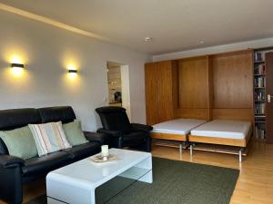 a living room with a couch and a table at Gipfelblick mit Hallenbad und Sauna in Bergen +16 photos