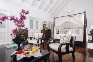 a bedroom with a bed and a table with a tray of food at The Inn at English Harbour in English Harbour Town
