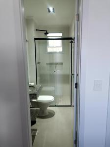 a bathroom with a toilet and a glass shower at Residencial Acquamare in Praia Grande