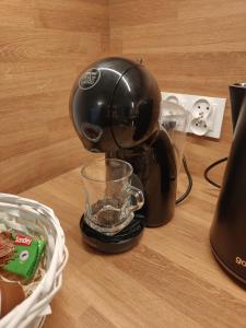 a coffee maker sitting on a table with a glass at Sweet Home Sielawy in Poznań
