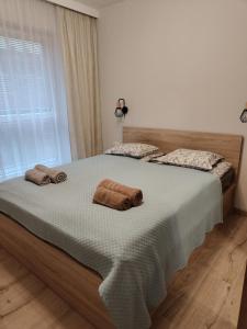 a bedroom with a large bed with two towels on it at Sweet Home Sielawy in Poznań