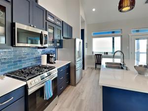 una cocina con estufa horno superior al lado de un fregadero en Heron House, en Rockport