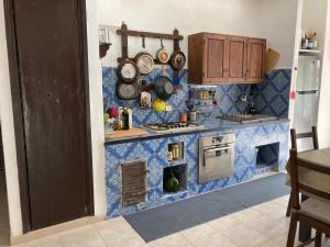 a kitchen with a blue tiled counter top at Noravilla con piscina fra mare e montagne in Mandra Capreria