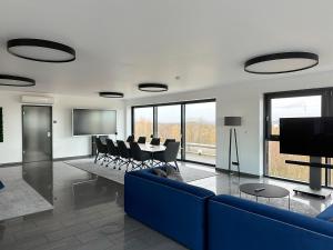 un salon avec un canapé bleu et une table dans l'établissement Infinity Apartment Essen, à Essen