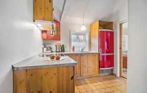 eine Küche mit einem roten Kühlschrank und Holzschränken in der Unterkunft 2 Bedroom Lovely Home In Blåvand in Blåvand + 19 Fotos