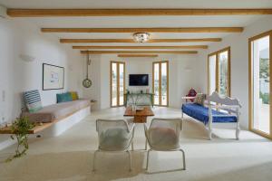 a living room with a bed and a couch and chairs at OceanLight Horizon - luxury Villa with private pool in Nea Cryssi Akti +40 photos