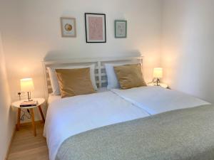 une chambre avec un grand lit blanc avec deux lampes dans l'établissement Apartments TENA with Private Parking, à Pula