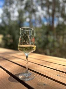 a glass of wine sitting on a wooden table at Casa Eucalipto in Firavitoba