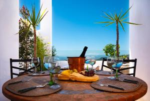 a table with wine glasses and food on it at CASA EMILIANA The Town-House Gaucin Spain in Gaucín