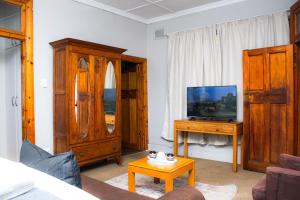 sala de estar con TV y armario de madera en Beechwood B&B, en Durban
