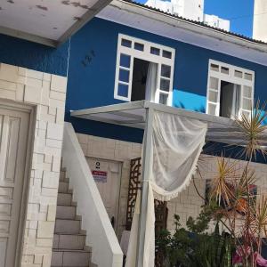 ein blaues Haus mit einer weißen Treppe davor in der Unterkunft Dois Pedros Balneário in Balneário Camboriú