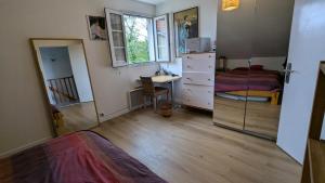 a bedroom with a bed and a desk and a bedroom with a bed gmaxwell gmaxwell at Maison Tranquille proche Paris et parc Asteric in Montmagny
