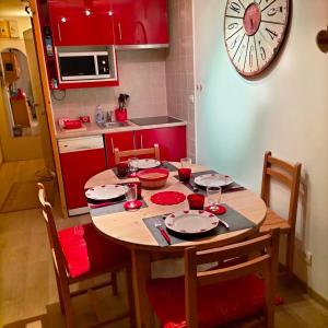 a kitchen with a wooden table and a clock on the wall at Lauzieres 209 Sud in Val Thorens