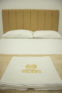 a bed with a white blanket on top of it at Hotel Boutique Don Polo in San Juan Nepomuceno