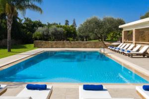 Una piscina con tumbonas y un resort. en Villa Melitini, en Suda
