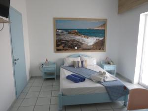 a bedroom with a bed with a painting on the wall at Blue Beach Villas Apartments in Stavros