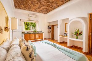 a living room with a large bed and a sink at Casa Real Sayulita Hotel Boutique in Sayulita