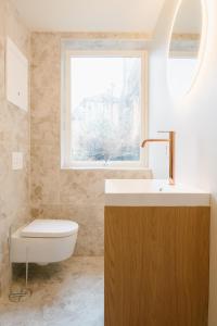 a bathroom with a sink and a toilet and a window at New Apartment in Historical street in Bergen