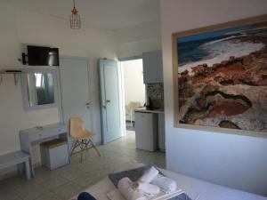 a room with a bed and a desk and a kitchen at Blue Beach Villas Apartments in Stavros