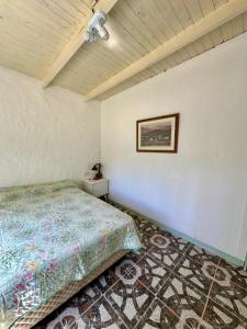 a bedroom with a bed and a picture on the wall at Casa Río General Belgrano in General Belgrano